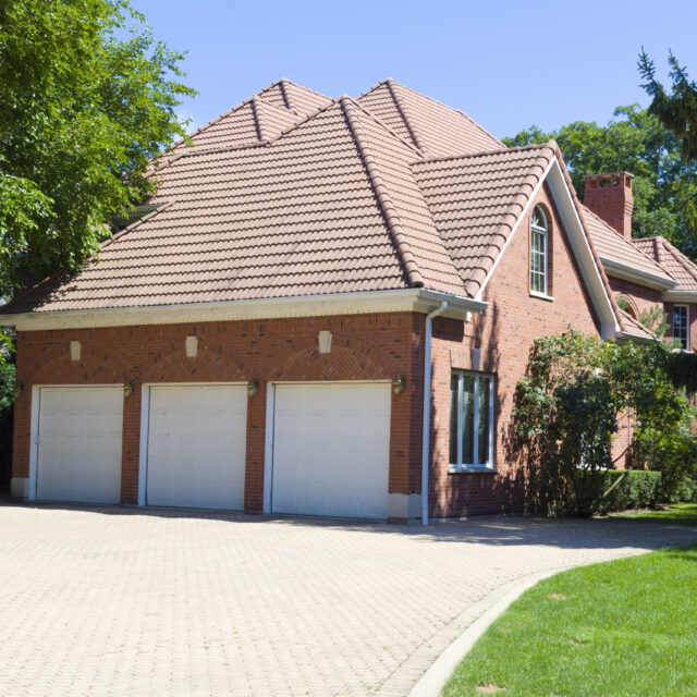 Red brick house with three garage doors.