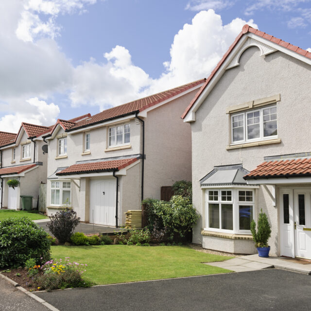 Three houses each with a white garage door.