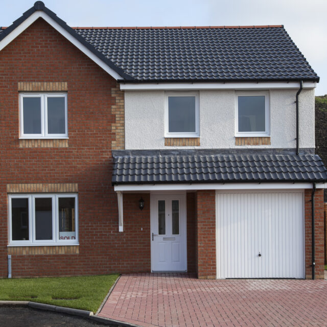 Single white garage door in a red brick house.